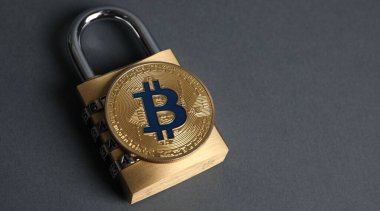Bitcoin ve asma kilit gri arka planda, yakın plan. Metin için boşluk