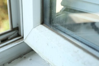 Pencere çerçevesi tozla kaplı, yakın plan.