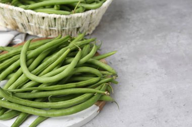 Fresh green bean pods on grey table, closeup. Space for text