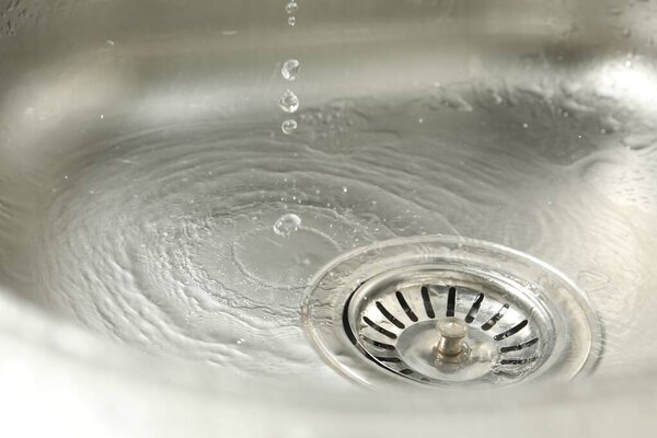 Water going down sink drain, closeup view