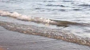 Güzel dalgalı deniz ve kumlu sahil, yakın çekim.