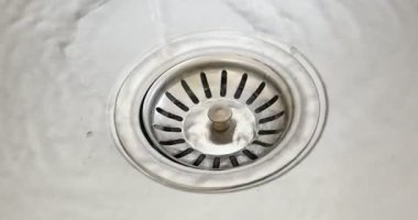 Water going down sink drain, closeup view