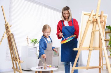 Meslek seçimi. Anne kızına stüdyoda resim yapmayı öğretiyor.