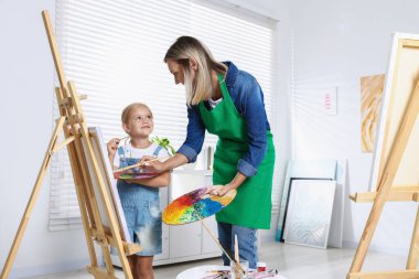 Meslek seçimi. Anne kızına stüdyoda resim yapmayı öğretiyor.
