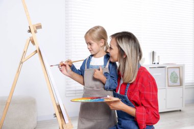 Meslek seçimi. Anne kızına stüdyoda resim yapmayı öğretiyor.