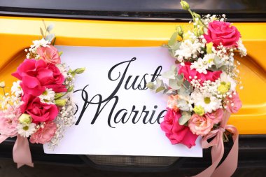 Düğün arabası. Cabriolet dekore edilmiş. Sadece evlilik kartı ve açık havada güzel çiçekler, yakın plan.