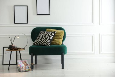 Şık lamba, sazlık dağıtıcı ve koltuk kenarında yastıklı dergi.