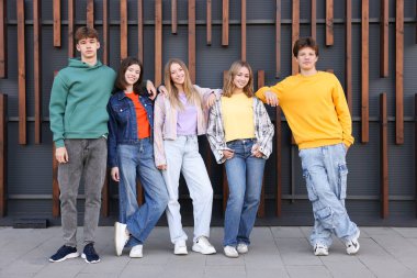 Şehir caddesindeki binanın yakınında bir grup genç.