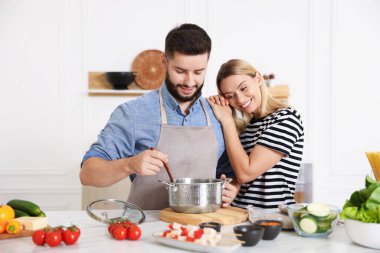 Mutfakta birlikte yemek pişiren mutlu çift.