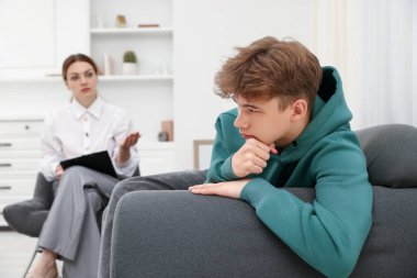 Ofiste genç bir çocukla çalışan profesyonel psikolog, seçici odaklanma