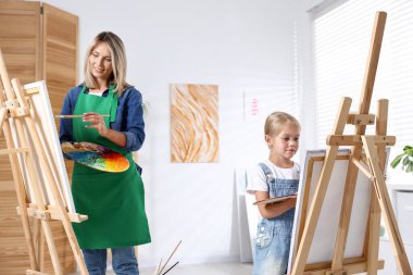 Meslek seçimi. Anne kızına stüdyoda resim yapmayı öğretiyor.