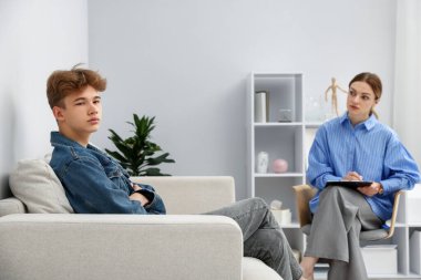 Ofiste genç bir çocukla çalışan profesyonel psikolog.