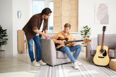 Öğretmenim evde gitar çalmayı öğretiyor.