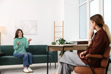 Ofiste genç bir kızla çalışan profesyonel bir psikolog.