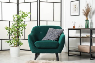 Yastıklı, konsol masalı ve dekorlu şık bir koltuk. İç tasarım