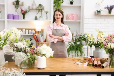 Dükkandaki ahşap masada çalışan profesyonel bir çiçekçi.