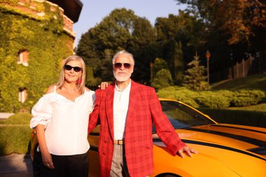 Modern Cabriolet yakınlarında güneş gözlüklü şık bir çift.