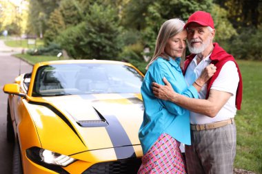 Modern Cabriolet yakınlarında şık bir yaşlı çift.