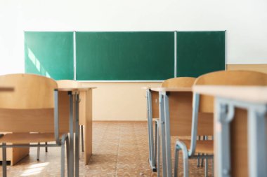 Sınıfta sandalyeli ve yeşil karatahtalı masalar