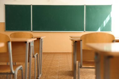 Sınıfta sandalyeli ve yeşil karatahtalı masalar