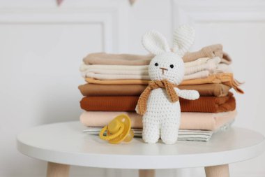 Temiz bebek kıyafetleri ve aksesuarlar beyaz masa içinde, yakın plan.
