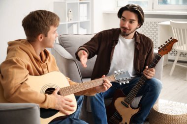 Öğretmenim evde gitar çalmayı öğretiyor.