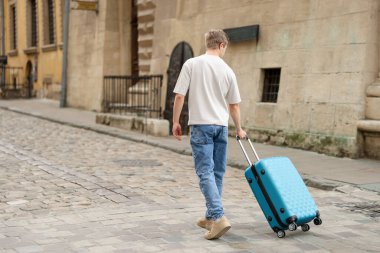 Hoşçakalın. Bagajlı bir adam dışarıda yürüyor, arka manzara. Metin için boşluk