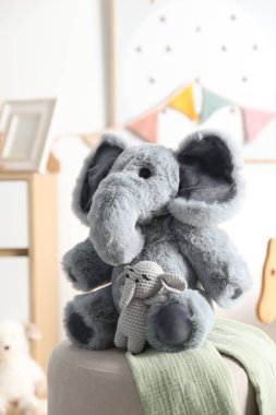 Çocuk odasında puf üzerinde sevimli oyuncak filler, yakın plan.