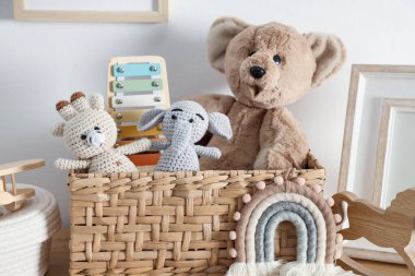 Beyaz duvarın yanındaki masada farklı şirin oyuncaklar ve dekorlar var.