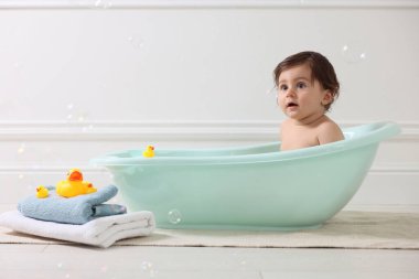 Evde küvette banyo yapan şirin bir bebek.