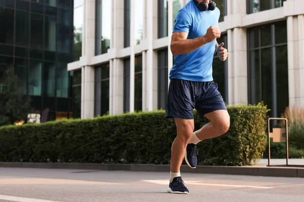 Şehir caddesinde koşan spor giysili bir adam, yakın plan. Metin için boşluk
