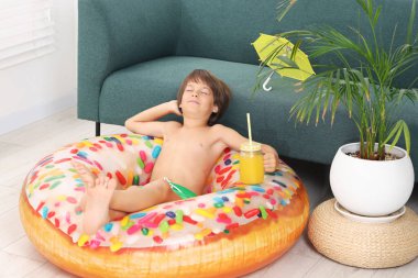 Denizde tatilin hayalini kuruyorum. Duvarcı kavanozunda taze meyve suyu ve şişme yüzükle küçük bir çocuk.