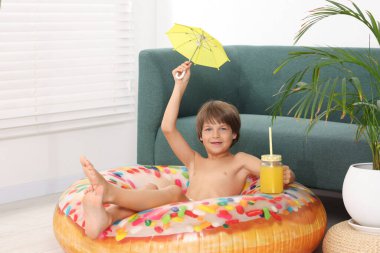 Denizde tatilin hayalini kuruyorum. Elinde mason kavanozu olan küçük bir çocuk. Taze meyve suyu, küçük bir şemsiye ve içeride şişme bir yüzük.