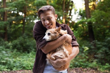 Mutlu adam dışarıda sevimli köpeğini tutuyor.