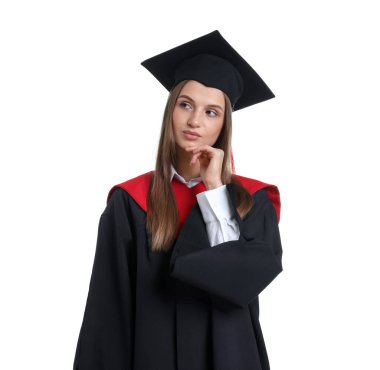 Mezuniyet elbisesi ve beyaz arka planda havan panosu olan düşünceli genç bir kadının portresi.