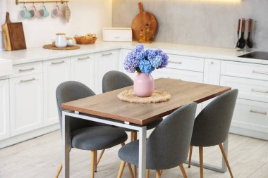 Dining table, chairs and floral decor in kitchen. Interior design
