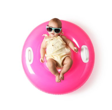 Beyaz arka planda şişirilebilir halkası olan güneş gözlüklü şirin bir bebek.