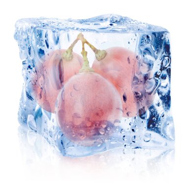 Beyaz zemin üzerinde buz küpünün içindeki taze üzümler