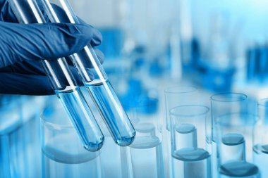 Laboratuvar analizi. Test tüpleri tutan bilim adamı, cam eşyayla iki kez maruz kalmış.