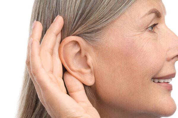 Звук. Старшая женщина показывает руку к уху жест на белом фоне, крупным планом