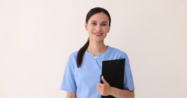 Üniformalı gülümseyen hemşire pano tutuyor ve arka planda iyi niyet gösterisi yapıyor.