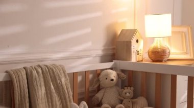 Evde bebek beşiğinde farklı çocuk oyuncakları. Kamera aşağı iniyor