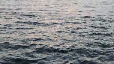 Güneşin doğuşunda güzel dalgalı deniz, kamera yükseliyor.