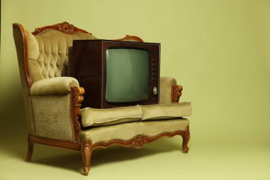 Retro TV seti ve zeytin arka planda kanepe, mesaj için yer. Kullanılmış eşyalar