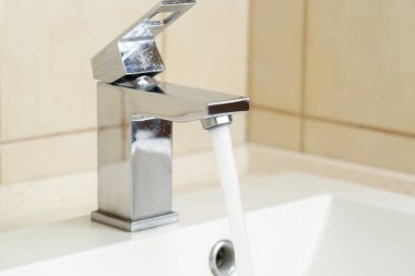 Su tasarrufu konsepti. İçerideki musluktan akan su akıntısı, yakın çekim