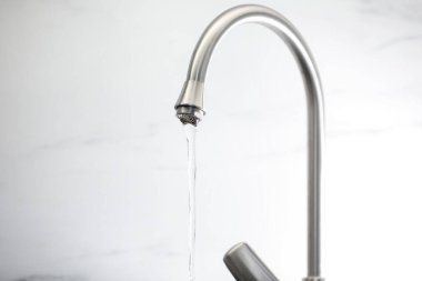 Su kavramını sakla. Musluktan akan su akışı hafif arka planda, yakın plan