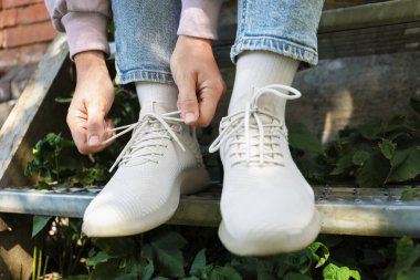 Dışarıdaki beyaz spor ayakkabılı kadın, yakın plan.