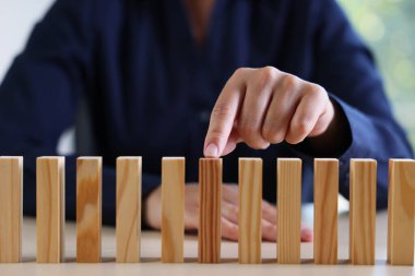 Risk. Kadın masadaki domino masasını işaret ediyor, yakın plan.