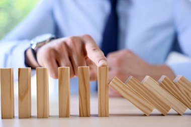 Risk. Masada domino etkisini durduran adam, yakın plan.