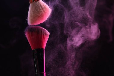 Siyah arka planda pembe göz farlı makyaj fırçaları, yakın plan. Metin için boşluk